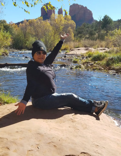 a woman in a black jacket sitting on a rock